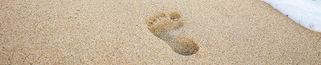 Footprints in the sand and sea wave